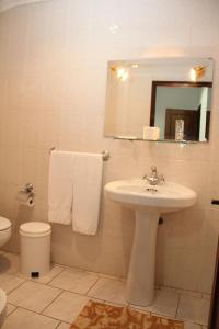 维达古Restaurante e Residencial O Resineiro的一间带水槽、卫生间和镜子的浴室