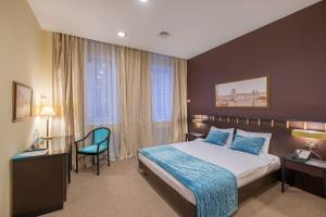 喀山伊梅列季酒店的配有一张床和一把椅子的酒店客房