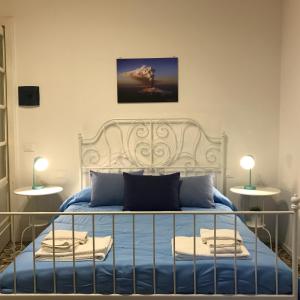 卡塔尼亚B&B Perla的一间卧室配有白色的床铺和蓝色的床单
