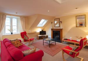 爱丁堡Parliament Sq (apt 5) Royal mile的客厅设有红色的沙发和壁炉