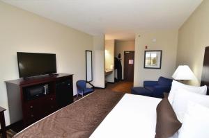 厄尔温Cornerstone Inn & Suites Oelwein的配有一张床和一台平面电视的酒店客房