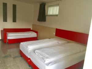 特伦托卡萨蓝博恩公寓的红色和白色的客房内的两张床