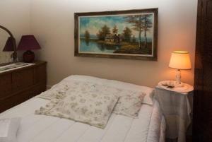 LucknowSommerville Court Motel Bed & Breakfast的卧室配有一张床,墙上挂有绘画作品