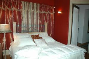 LucknowSommerville Court Motel Bed & Breakfast的卧室配有白色的床铺和红色的墙壁