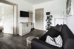 圣洛伦佐-迪塞巴托Haus Spielbichl的客厅配有黑色沙发和电视
