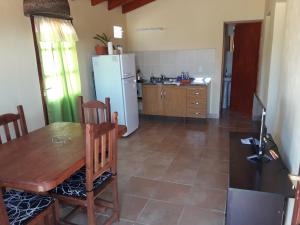 卡奇Cabaña Los Molles的厨房配有木桌和冰箱。