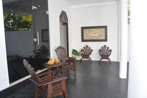 高尔Star Nodes Villa的一间设有椅子和桌子的房间,上面有水果