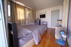 Ban Khao Ya Nua考考庞苏福默克度假村的一间卧室配有一张带风扇和窗户的床。
