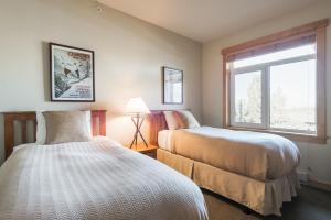 老猛犸湖Sunstone 325的一间卧室设有两张床和窗户。