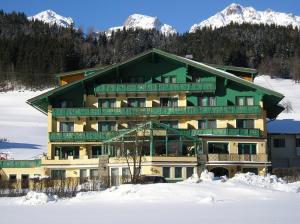 斯拉德明Hotel Druschhof的雪中一座大建筑,有雪盖的山