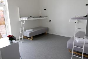 布伦讷斯莱乌Hostel Brønderslev的客房设有两张双层床和一张沙发。