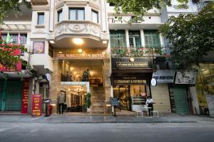 河内Hanoi Center Silk Premium Hotel & Spa & Travel的城市街道上一座有商店的建筑