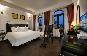 河内Hanoi Center Silk Premium Hotel & Spa & Travel的一间卧室配有一张床、一张书桌和一台电视。