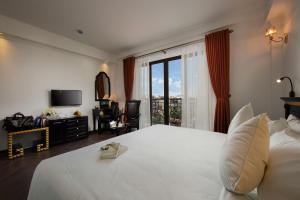 河内Hanoi Center Silk Premium Hotel & Spa & Travel的卧室设有一张白色大床和一扇窗户。