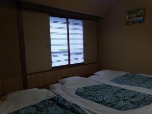 东京艾多亚酒店的带窗户的客房内的两张床