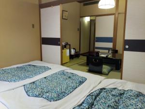 东京艾多亚酒店的一间卧室配有两张床、一张桌子和一面镜子