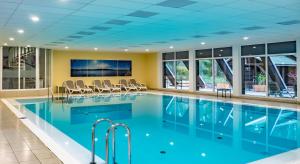 滕普林杜勒西-是弗黑德酒店的游泳池,带椅子和电视