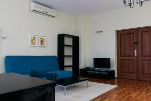 弗沃茨瓦韦克Apartamenty „Lofty w piecowni”的客厅配有蓝色的沙发和电视