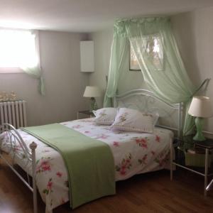 南特Agora Mijo Chambre d'Hôtes的一间卧室配有一张带绿色和白色棉被的床