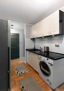 华沙ClickTheFlat Hoża Street Apart Rooms的厨房配有洗衣机和冰箱。