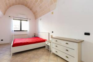 圣维托诺曼Casa Sardelli的一间卧室配有红色的床和梳妆台