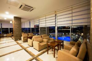 锡德Ramada Resort Side的大堂配有沙发、桌子和窗户。