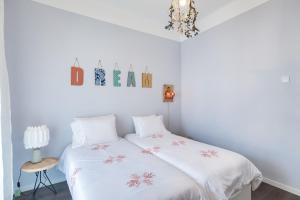 丰沙尔Endemic - Concept Apartment的一间卧室配有一张带白色床单和吊灯的床。