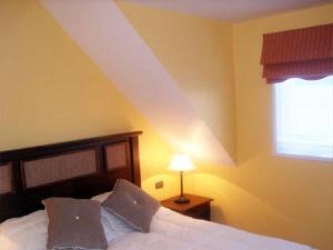 蒙特港Apart Hotel en Puerto Montt的一间卧室配有一张带白色床单的床和一扇窗户。