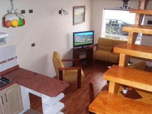 蒙特港Apart Hotel en Puerto Montt的客厅配有桌子、沙发和电视