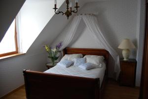 埃尔盖加贝里克La Roseraie的一间卧室配有一张带天蓬的白色床