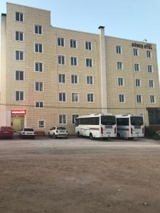 HacıbektaşGunes Hotel的两辆公共汽车停在大楼前的停车场