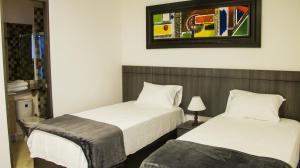 圣玛尔塔Hotel Viña Del Mar的卧室配有两张床,墙上挂着一幅画