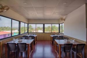 巴加巴加海滩埃尔罗酒店的用餐室设有桌椅和窗户。