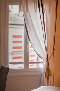 巴黎伊波利特住宿加早餐旅馆的客房内的白色窗帘窗户