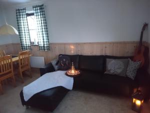 GranbergetFjällsikten Apartment的客厅配有黑色沙发和桌子