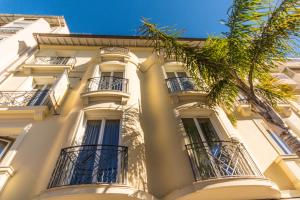 胡安莱潘Résidence Villa d'Elsa的带阳台的白色建筑和棕榈树