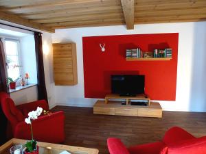 柯尼希斯湖畔舍瑙Haus Irlinger的客厅设有红色的墙壁和电视。