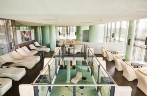 朗根洛伊斯LOISIUM Wine & Spa Hotel Langenlois的大堂设有白色家具和玻璃地板
