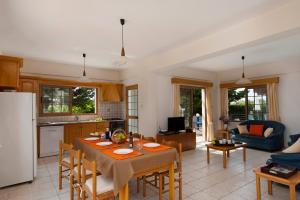 珊瑚湾帕纳乐丽珊瑚湾度假酒店的厨房以及带桌椅的起居室。