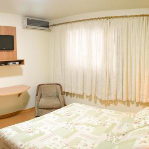VacariaPampa Hotel的卧室配有床、椅子和窗户。