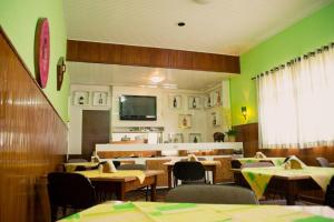 VacariaPampa Hotel的餐厅拥有绿色的墙壁和桌椅