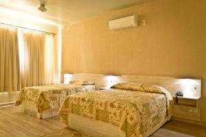 VacariaPampa Hotel的酒店客房设有两张床和窗户。