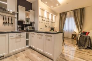 博洛尼亚Ugo Bassi Apartments的厨房配有白色橱柜和台面