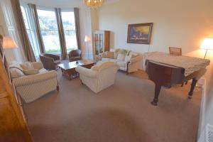 CarrickBeach House - Carrick Castle的客厅配有三角钢琴和椅子