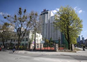 华沙乌茨卡艾登公寓的骑着自行车沿着大街上高楼的人
