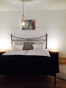 圣温德尔Ferienhaus mit Sonnendeck的一间卧室配有一张带两张桌子的黑色床