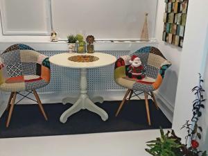 蒂米什瓦拉The Kiss Apartment的一张桌子,两把椅子,一张桌子,上面有桑塔语句