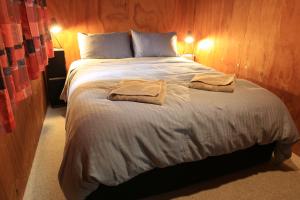 HikutaiaEarthbridge的一间卧室配有一张大床和两条毛巾