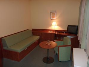 德尔内夫奥里克普拉哈酒店的带沙发、桌子和书桌的客房