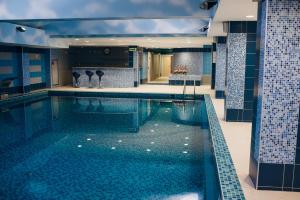 阿克套里海海滨皇宫大酒店的蓝色瓷砖建筑中的一个大型游泳池